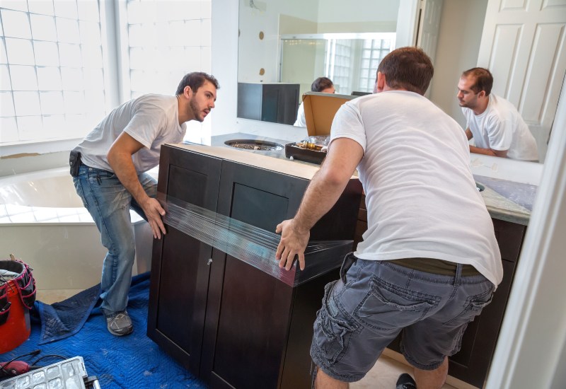 Two men are working together on a bathroom cabinet for a remodeling project in Annapolis, MD.
