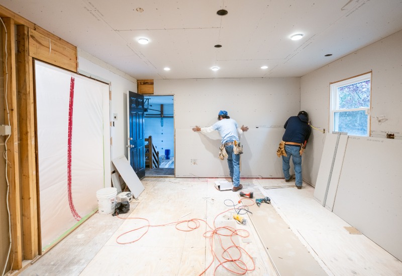 Two men engaged in a whole-house renovation, using various construction materials in Annapolis, MD.